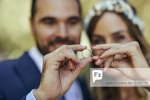 Happy bridal couple showing their wedding rings close-up