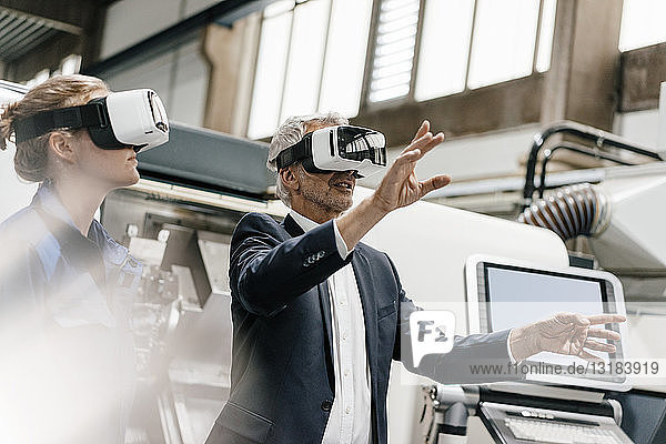 Businessman and skilled worker in high tech enterprise  using VR glasses