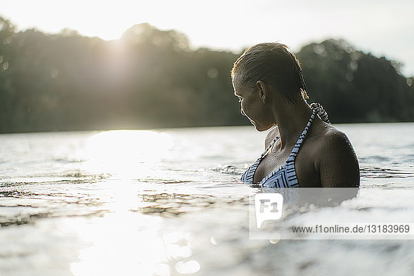 Frau in einem See bei Sonnenuntergang