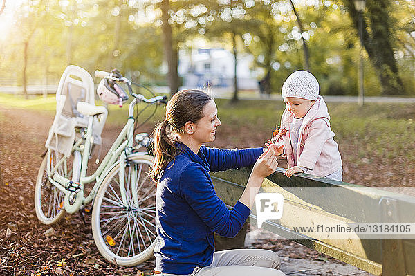 Mother and daughter taking a break on a park bench