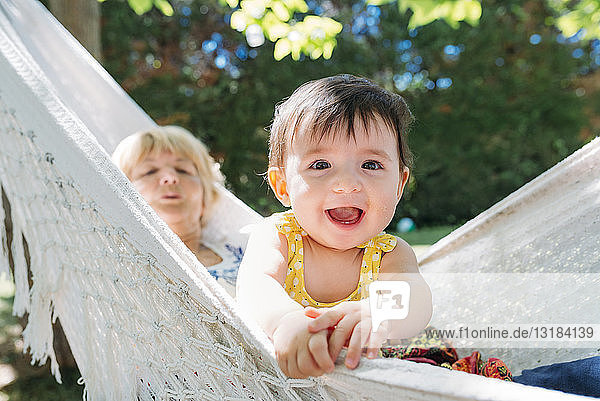 Spanien  Oma und Baby entspannen sich im Sommer in einer Hängematte im Garten