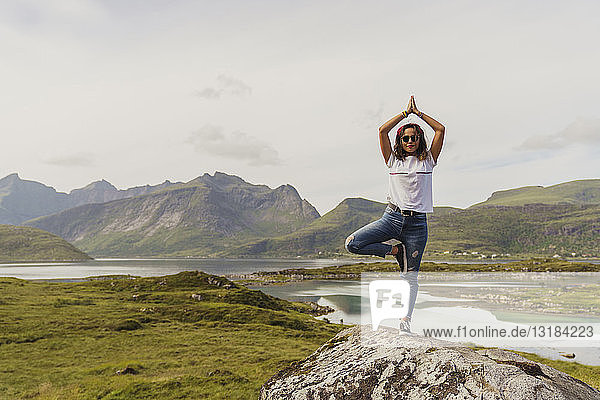 Junge Frau  die Yoga in der Natur praktiziert  Lappland  Norwegen