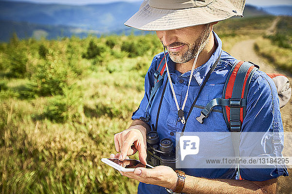 Man checking his cell phone during hiking trip