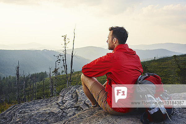 Man sitting on rock enjoying the view during hiking trip