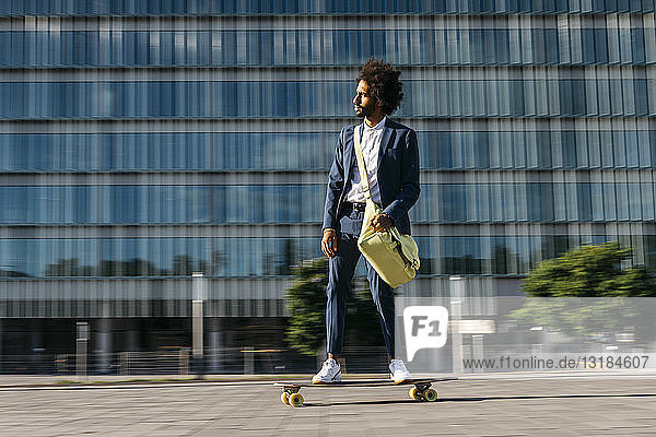 Spanien  Barcelona  junger Geschäftsmann fährt Skateboard in der Stadt