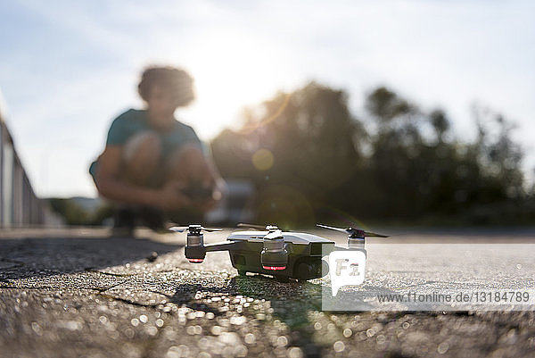 Boy landing his drone on the street
