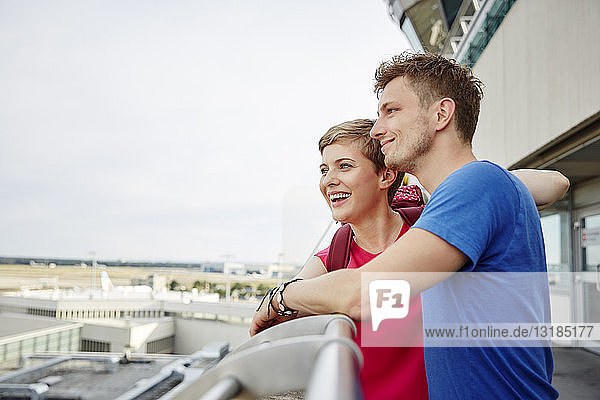 Glückliches Paar auf der Aussichtsplattform des Flughafens