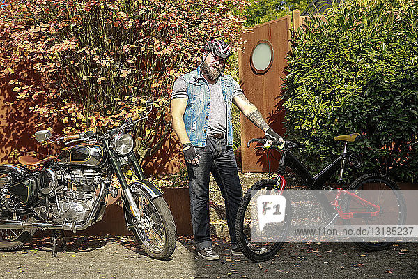 Porträt eines Mannes  der vom Motorrad aufs Fahrrad umsteigt