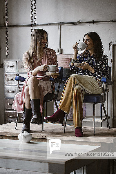 Zwei Freunde trinken gemeinsam Tee auf einem Dachboden