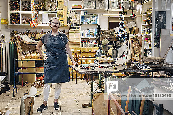 Portrait of female craftsperson standing in upholstery workshop