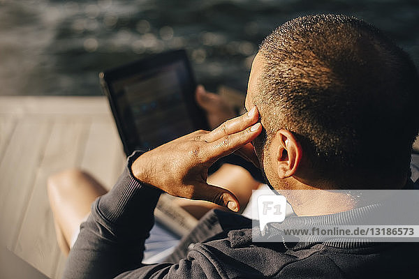 Hochwinkelansicht eines Mannes mit digitalem Tablett auf der Terrasse