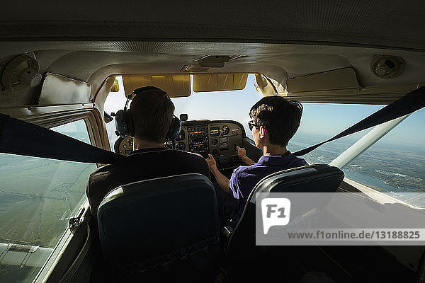 Father and son flying small airplane