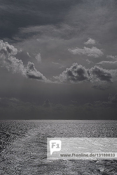Schwarze und weiße Gewitterwolken über dem Meer
