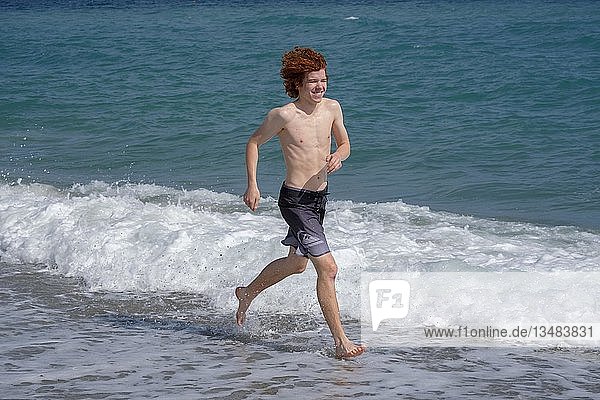 Hellhäutiger  rothaariger Teenager beim Joggen am Meer  Strand  Finale Ligure  Riviera di Ponente  Ligurien  Italien  Europa