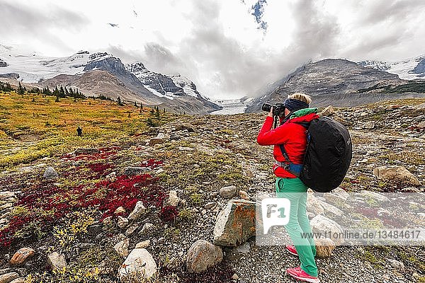Young woman photographs barren landscape  glacier valley  Mount Athabasca with Saskatchewan Athabasca Glacier  Icefields Parkway  Jasper National Park National Park  Canadian Rocky Mountains  Alberta  Canada  North America