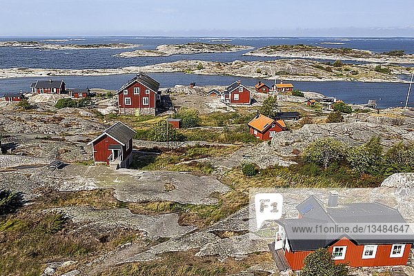Rote Holzhäuser an der felsigen Küste  Stockholmer Schären  Schäreninsel Huvudskär  Schweden  Europa