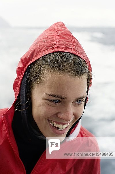 Junge Frau sitzt im Regen am Heck eines kleinen Bootes  Isola Eolie  Sizilien  Italien  Europa