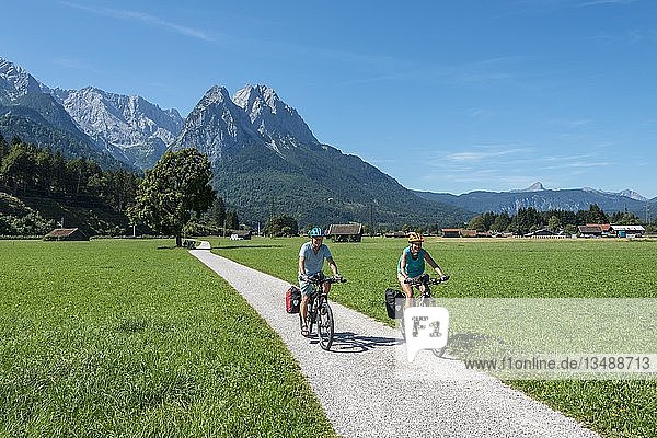 Cyclists on bike tour  cycle path with mountain bike  behind Zugspitze  Tegernauweg  near Grainau  crossing the Alps  Garmisch-Partenkirchen  Upper Bavaria  Bavaria  Germany  Europe