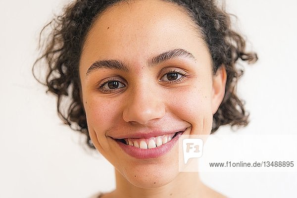 Porträt einer jungen lächelnden Frau vor einem weißen Hintergrund  Deutschland  Europa
