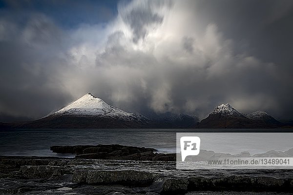 Große Felsen im Wasser der Nordsee mit schneebedeckten Cullin-Bergen im Hintergrund  Elgol  Isle of Skye  Schottland  Vereinigtes Königreich  Europa