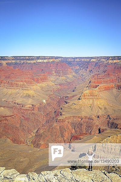 Frau  Person mit erhobenen  ausgestreckten Armen vor der gigantischen Schlucht des Grand Canyon stehend  Blick vom Rim Trail  zwischen Mather Point und Yavapai Point  erodierte Felslandschaft  South Rim  Grand Canyon National Park  bei Tusayan  Arizona  USA  Nordamerika
