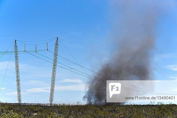 Stromleitung mit Dust Devil Staubteufel Sandsturm mit viel Asche über verbrannter Pampa Patagonien Argentinien Südamerika