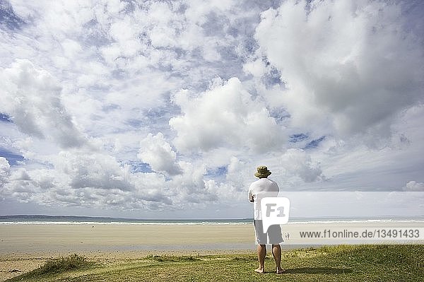 Ein Mann auf einer Düne mit Blick auf das Meer  Bretagne  Frankreich  Europa