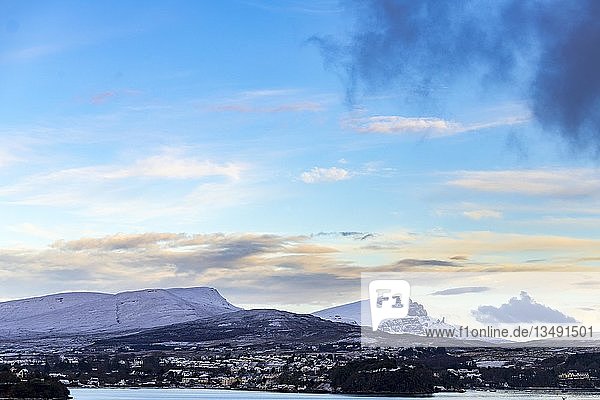 Portree im Winter bei Sonnenaufgang mit Old man of Storr und Bergen im Hintergrund  Portree  Isle of Skye  Schottland  Vereinigtes Königreich  Europa