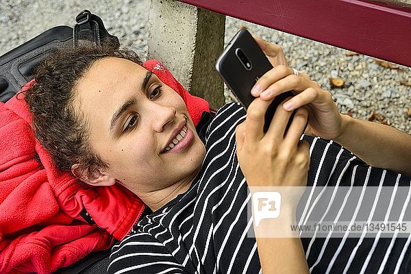 Junge Frau  die ein Smartphone benutzt und darauf schaut  Mobiltelefon  Deutschland  Europa