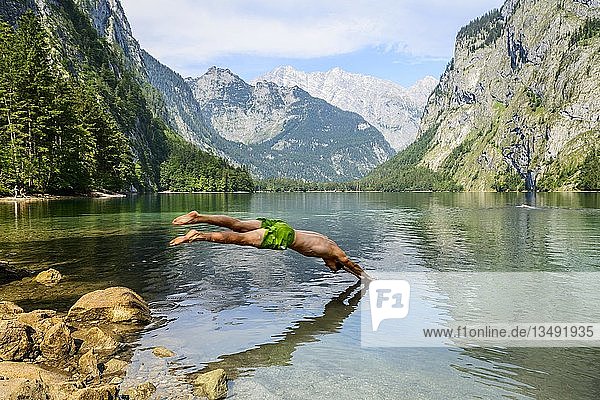 Junger Mann springt in den Obersee  Schwimmen  Bergsee  Berglandschaft  im hinteren Watzmann-Massiv  Salet am Königssee  Nationalpark Berchtesgaden  Berchtesgadener Land  Oberbayern  Bayern  Deutschland  Europa