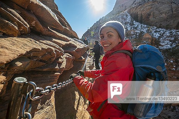 Junge Frau beim Wandern auf dem Klettersteig des Angels Landing Trail  im Winter  Zion Canyon  Berglandschaft  Zion National Park  Utah  USA  Nordamerika