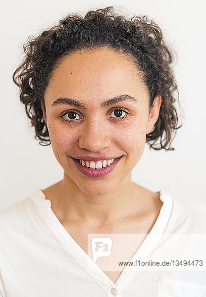 Portrait of a young smiling woman against a white background  Germany  Europe