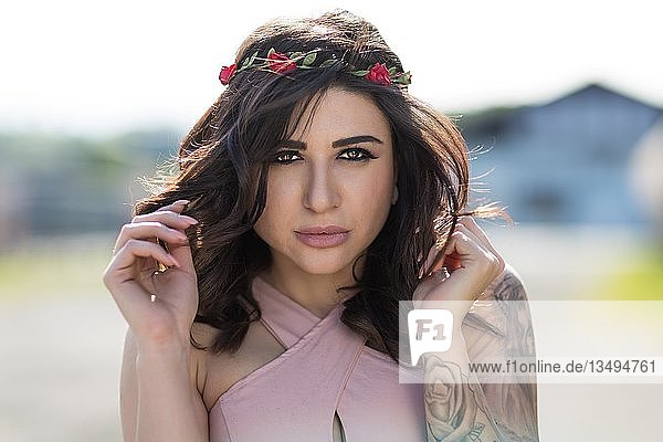 Portrait of a young woman with dark long hair and flowery wreath  fashion