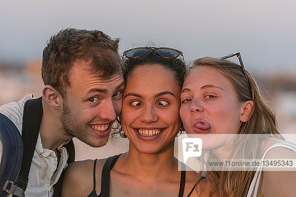 Two young women and young man look into the camera  make a grimace  make friends  Plaza de la Encarnacion  Seville  Andalusia  Spain  Europe