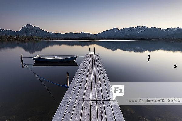 Abendlicht auf dem Hopfensee mit Steg und Ruderboot  im Hintergrund die Allgäuer Alpen  Füssen  Ostallgäu  Allgäu  Bayern  Deutschland  Europa