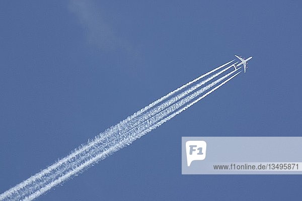 Airplane and condens trails in the blue sky