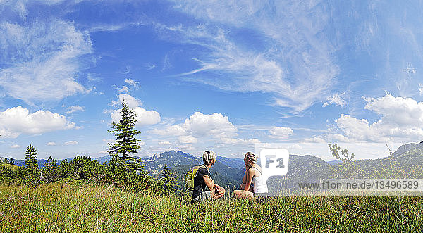 Mother and daughter resting on Weisenbachkopf mountain  with view to the Tegernsee Mountains  Wildbad Kreuth  Bavaria  Germany  Europe