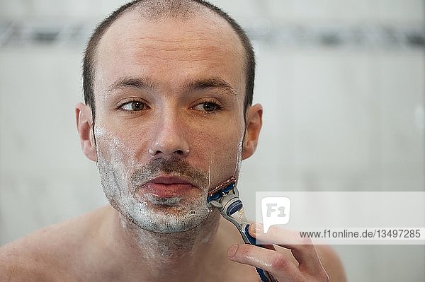 Junger Mann beim Rasieren