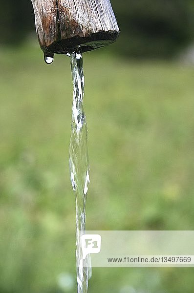 Stream of water flowing from a wooden fountain  well