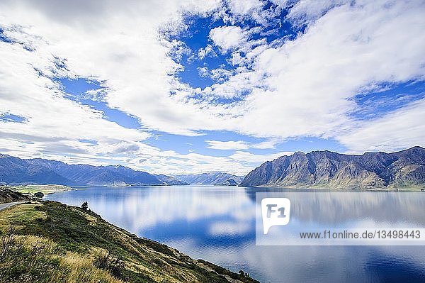 Bewölkter Himmel mit Wasserreflexionen im Hawea-See  Haast Pass  Südinsel  Neuseeland  Ozeanien