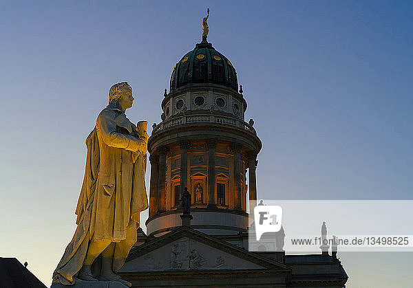 Schiller-Skulptur auf dem Gendarmenmarkt vor der Kuppel des französischen Doms am Abend Berlin Deutschland Europa