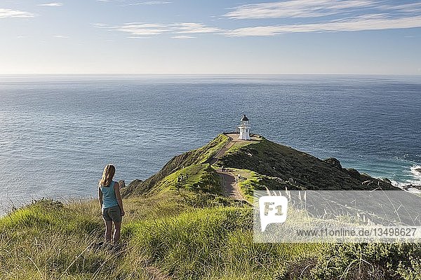Woman stands in front of lighthouse at Cape Reinga  Northland  North Island  New Zealand  Oceania
