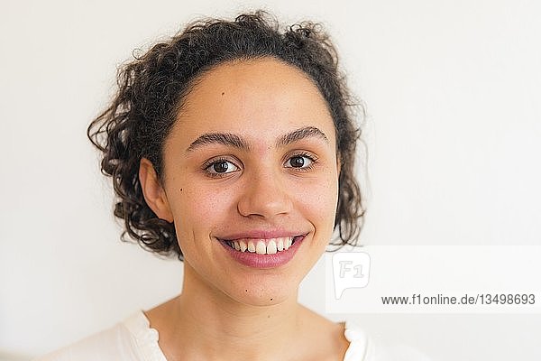 Portrait of a young smiling woman against a white background  Germany  Europe