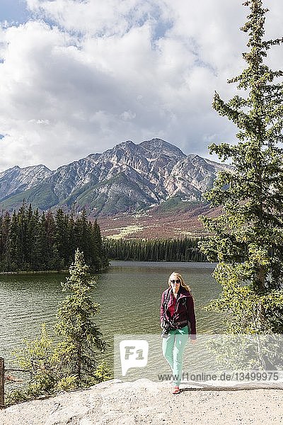 Female hiker stands on the lakeshore  Pyramid Lake  back mountains  Pyramid Mountain  Jasper National Park National Park  Canadian Rocky Mountains  Alberta  Canada  North America