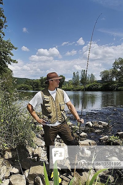 Angler with rod at the water