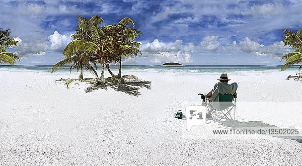 Mann mit Sonnenhut auf einem Stuhl sitzend an einem Strand in der Karibik bei Punta Allen  Mexiko  Nordamerika  Mittelamerika