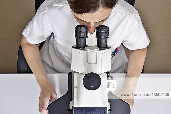 Wissenschaftlerin bei der Verwendung eines Mikroskops in einem Labor  Vereinigtes Königreich  Europa