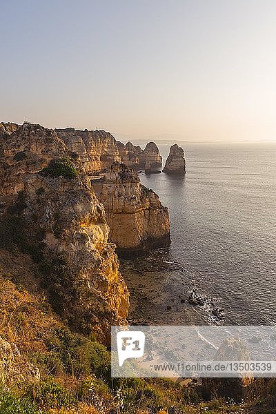 Sonnenaufgang über dem Meer  felsige Küste aus Sandstein  Felsformationen im Meer  Algarve  Lagos  Portugal  Europa