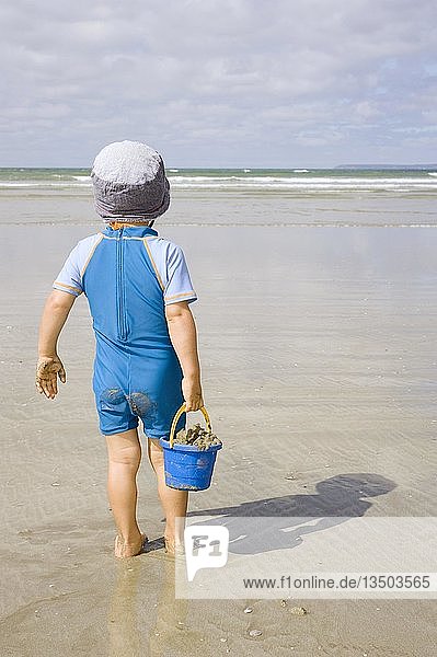 Junge steht am Strand an der Atlantikküste  Bretagne  Frankreich  Europa