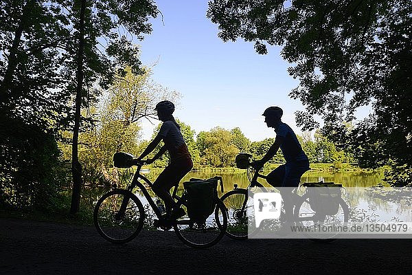 Silhouette  cyclists on the Isar at Loiching  Eastern Bavaria  Lower Bavaria  Bavaria  Germany  Europe
